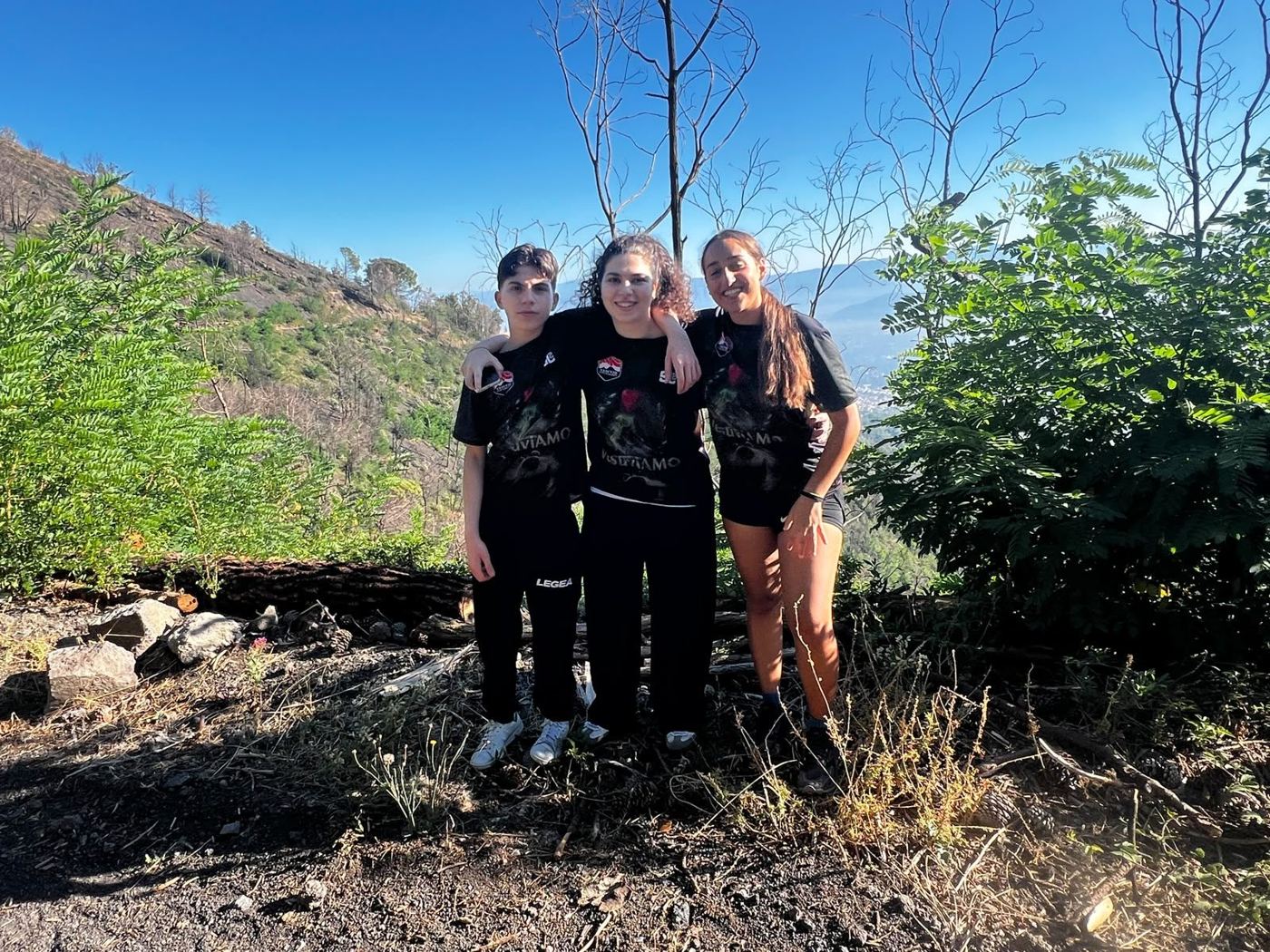 Tre ragazzi in posa a un belvedere sul versante del vulcano