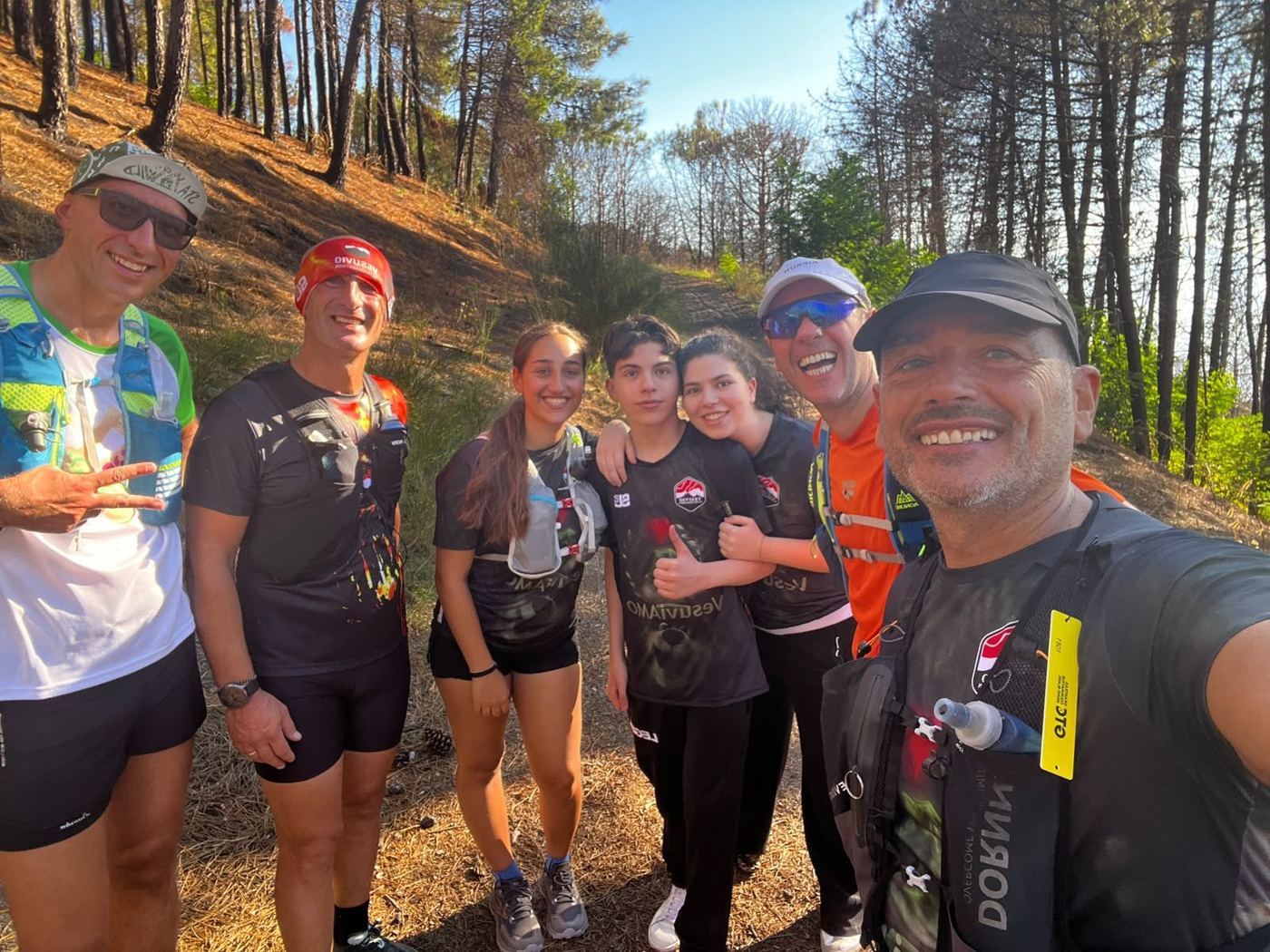Selfie di gruppo di runner sorridenti in una pineta